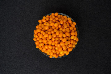 Sea buckthorn on a white background. Natural, organic sea buckthorn berries in a bowl