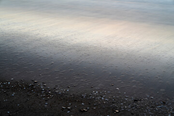 Long exposure of the sea on the shore of the beach of the town of Villajoyosa.