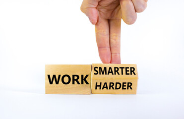 Work harder or smarter symbol. Businessman turns wooden block and changes words 'work harder' to 'work smarter'. Beautiful white background, copy space. Business and work harder or smarter concept.