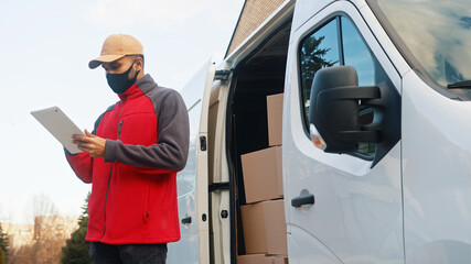 Delivery man employee with face mask delivering package. High quality photo