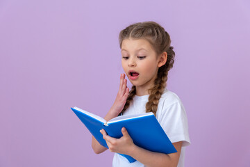 A little girl is very surprised to read an interesting book.