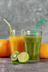 Two tall glasses of orange juice and a banana-orange kiwi and spinach smoothie
