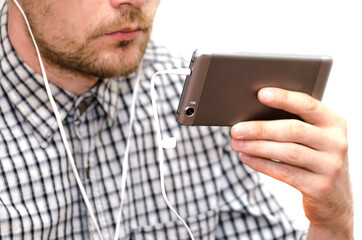 Man listens to music on headphones, from his phone