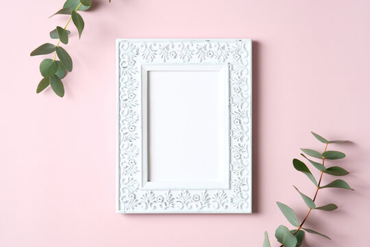 Photo frame mockup and eucalyptus leaves on pink background. Happy Mothers Day, love, romance concept.
