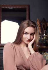 Fototapeta premium beautiful girl in a dress stands and looks at the lens