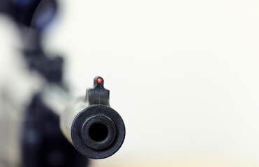 Air rifle with an optical sight on a light background