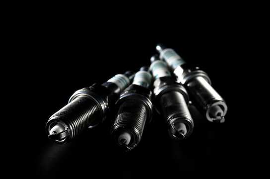 spark plugs for a car engine on a dark background