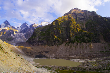 Fototapeta na wymiar Lake Bashkara Lower on the background of mountain ranges in the Elbrus region