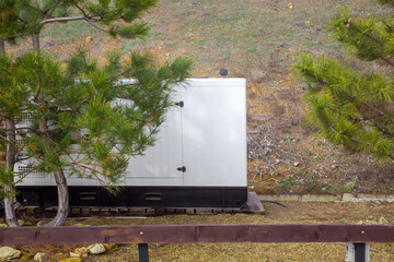 backup generator of standby power in case of power outage, installed outdoors on clay soil near...