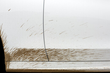 dirty car in the spray of the swamp the driver door and the front fender of the vehicle closeup,...