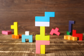 Multicolored puzzle, cubes on a wooden background