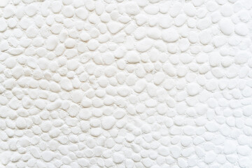 Naklejka na ściany i meble Wall texture with white stones of round shapes to use as a background.