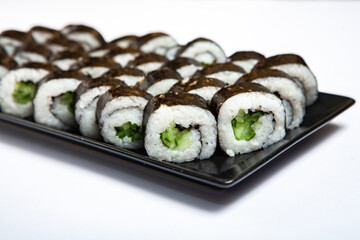 Fresh delicious japanese sushi with avocado on white background.