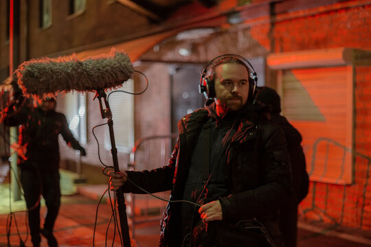 Sound engineer with a microphone on the set. A professional sound engineer at work on the filming of a movie