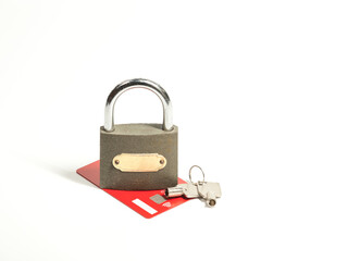 A gray metal padlock with a pair of keys, coins and red credit card on the white background