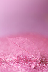 skeleton leaves.Skeletonized pink leaf close-up in pink glow glitter on a  lilac background.Wallpaper phone shining glitter. Beautiful nature background in pink tones with shining bokeh