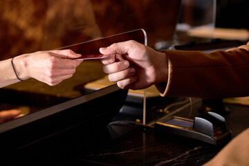 cropped man in Hotel check in at reception or front office being given key card close-up hands