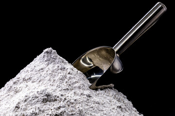 magnesium sulfate on black isolated background with metal spoon