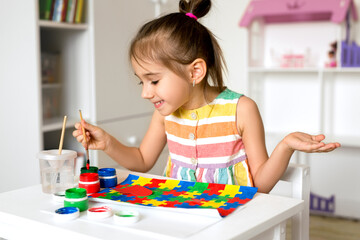 World Autism Awareness Day . The child draws bright colorful puzzles with gouache.  A creative...