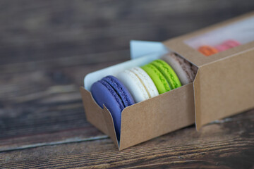 Colored macaroon cakes in a paper box