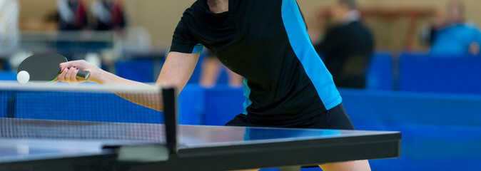 Ping pong table, woman playing table tennis with racket and ball in a sport hall