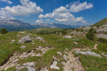 Panorama of Sella Massif and Puez Odle Park with unrecognizable man walking on a hiking trail, Dolomites, Italy