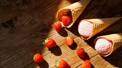 Strawberry ice cream in a waffle cone. Red berries and ice cream balls