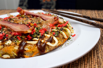 The asian food with bacon in te withe plate