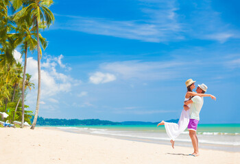 young couple on their honeymoon having fun by tropical beach