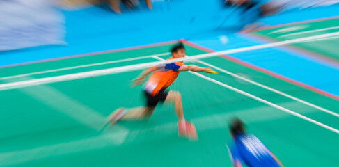Professional badminton player beats the shuttlecock in the arena. Blurred motion abstract background
