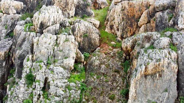 Upward drone shot over rock cliff reveal the Galilee sea over the Arbel Cliff,Israel, aerial shot