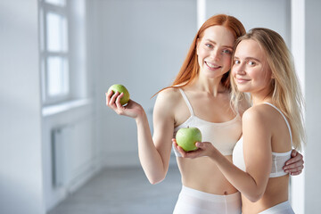 Happy Women With Blonde And Red Hair Posing With Green Apples