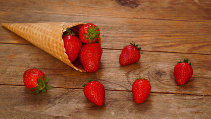 Ice cream cone with strawberries on a wooden background