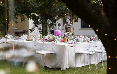 Mesa preparada y decorada para banquete de boda con mantel, servilletas, cubertería y arreglos...