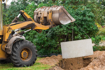 Hydraulic piston system of the excavator with a bucket, lowering into the pit on steel cables...