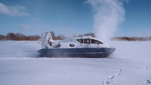 Aerial photography: Hovercraft rides on an ice-covered river in winter