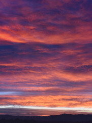 Epic scene of a cloudy sky during sunrise with purple and pink colors