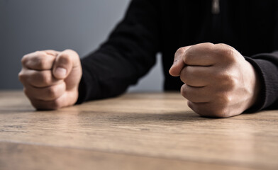 man fists on a wooden table