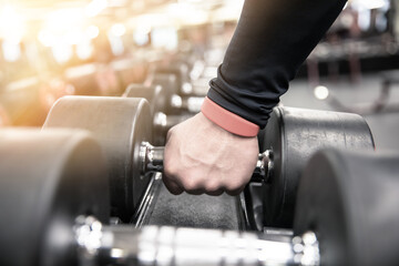 man exercising by lifting dumbbells
