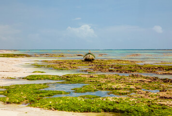 old handmade african  dhow fishing wooden boat anchored in the ocean in sunny weather