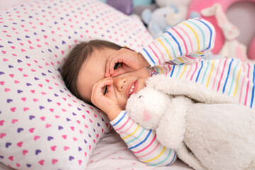Toddler girl making binoculars with her hands.
