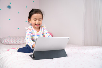 Joyful young child using digital tablet.