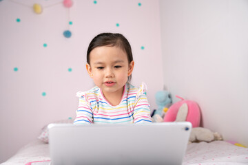 Little girl attending virtual class using digital tablet.