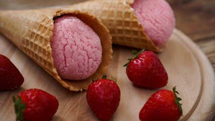 Strawberry ice cream in a waffle cone. Red berries and ice cream balls