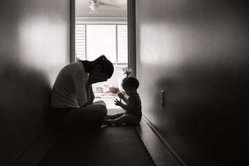 Silhouette of tired, stressed mother housewife taking care of child. Family problems, abuse, and...