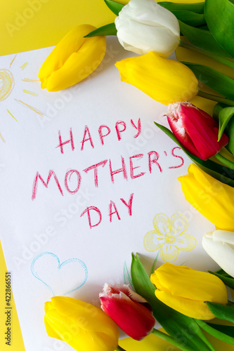 Greeting card for Mom drawn by child on Mother's Day with the inscription "Happy mother's day" with colorful tulips in bouquet of flowers on yellow background.