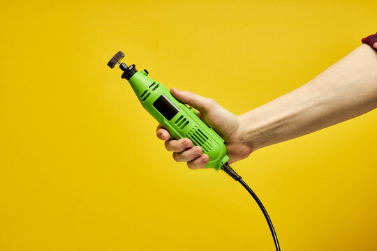 copy space, close-up green die grinder in cropped male hands
