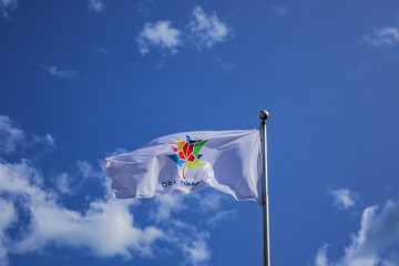 A Canadian flag with an inscription 'Canada 150' with maple leaf fluttering against the blue sky.