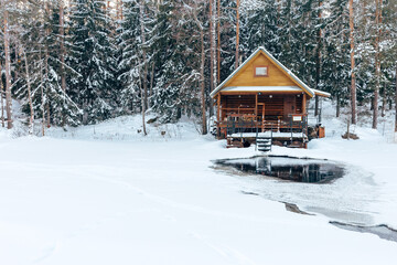 russian sauna banya house in winter forest nearby the lake with ice-hole