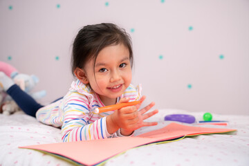 Cute little girl drawing in her room..
